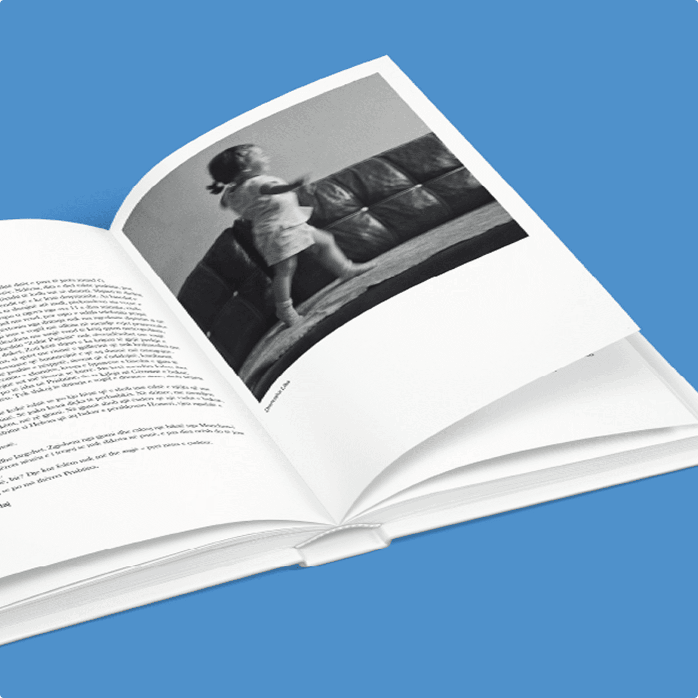 An open spread of the anthology showing literary text on the left page and a black-and-white photograph of a child climbing on a leather sofa on the right.